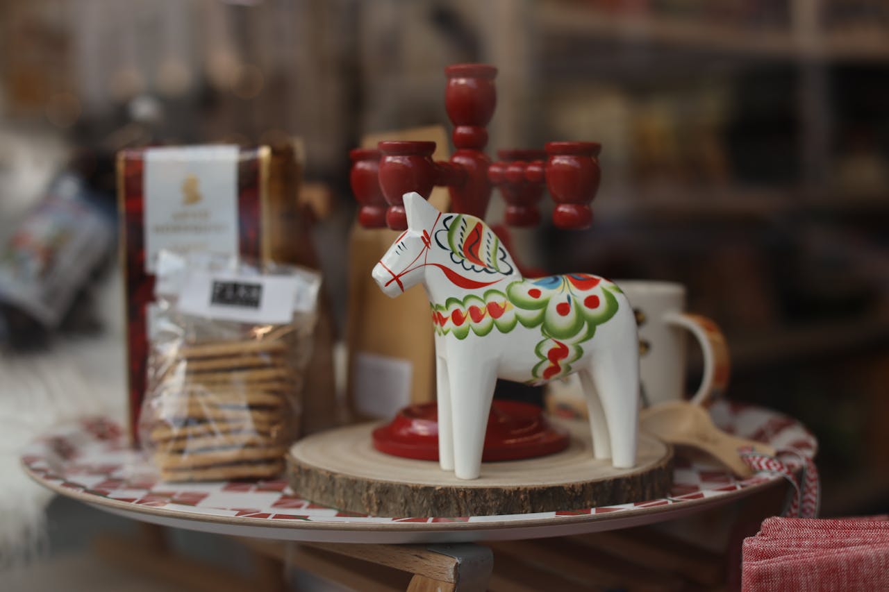 Decorative wooden ornament horse paired with red candlesticks in a cozy setting.